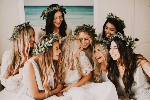groupe de jeunes femmes qui rigole avec des couronnes de fleurs sur la tete