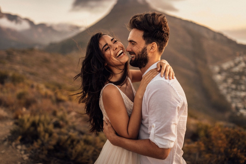 couple qui rigole dans les montagnes au coucher de soleil