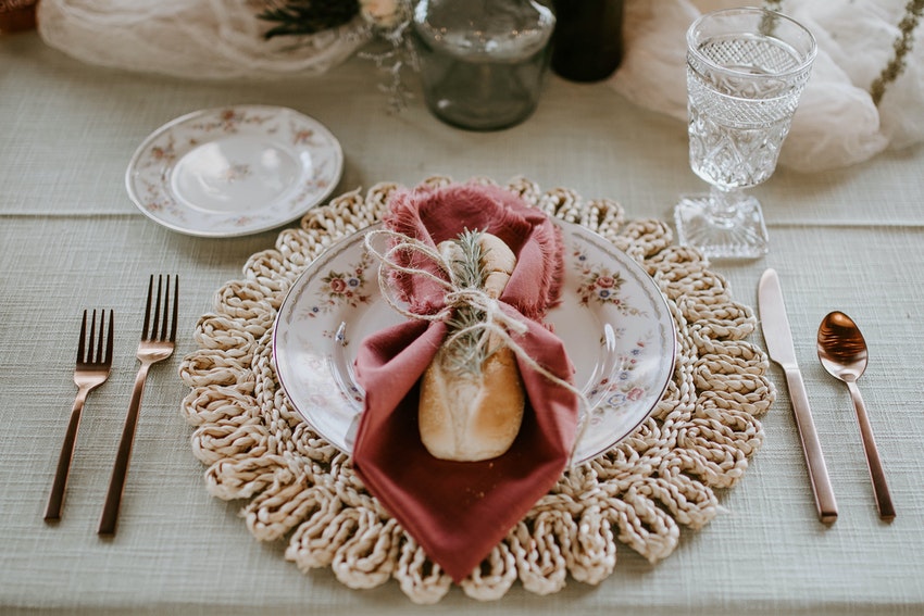assiette sur table avec serviette rose et couverts