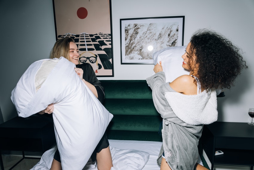 deux jeunes filles en tenue de pyjama faisant une bataille de taie d oreiller