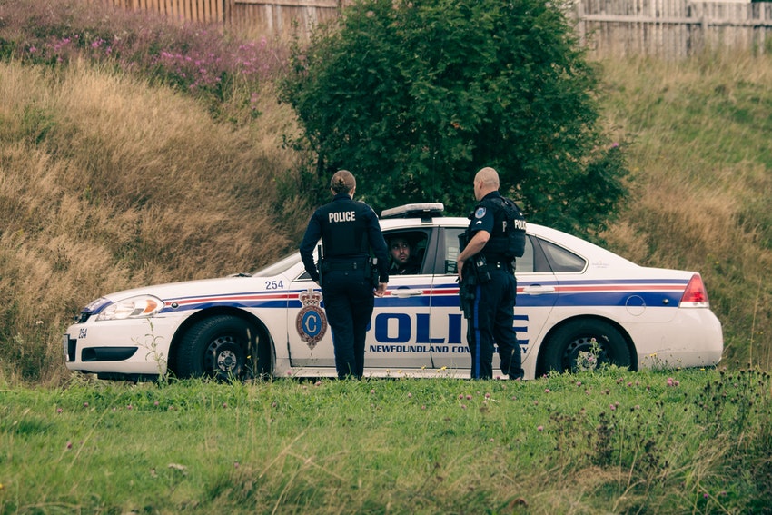 deux policiers proche de leur voiture de police