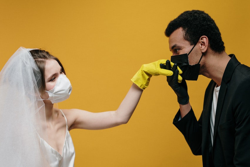 epoux masques et gantes en tenue de mariage