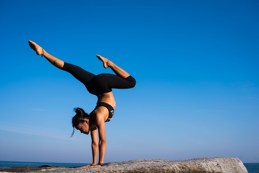 femme faisant du yoga avec un ciel bleu en fond
