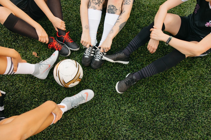 groupe de filles en tenue de sport ballon au centre de leurs jambes