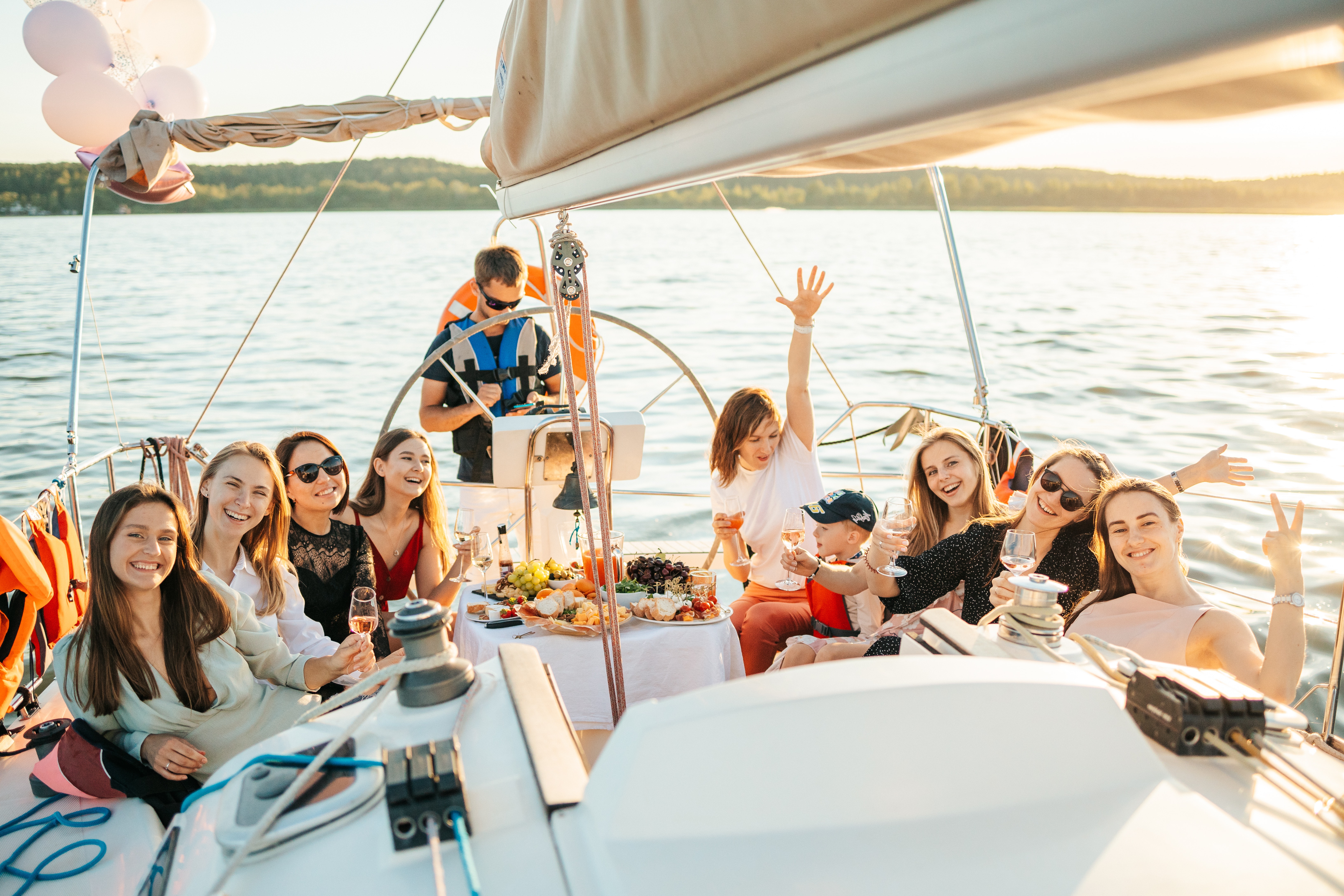 groupe de filles sur un bateau voilier assisent avec le skipper sur la photo