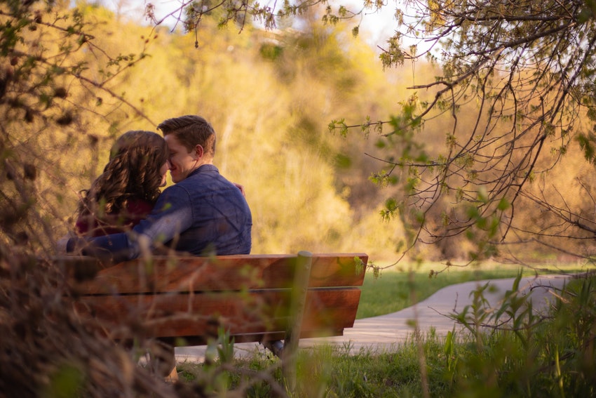homme et femme assis sur un banc s'embrassant