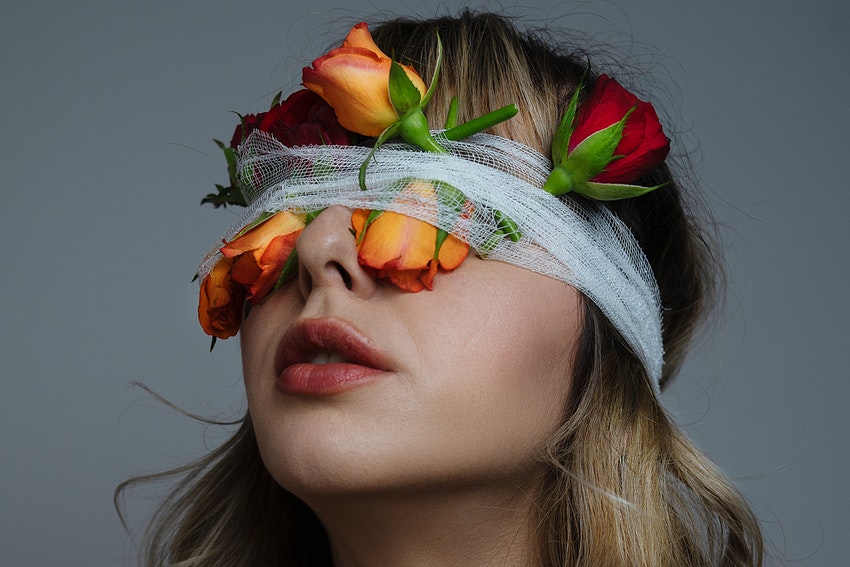 jeune femme yeux bandés avec fleurs sur le voile blanc