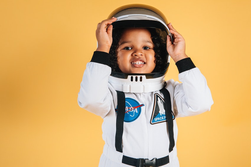 petite fille habillee en astronaute sur fond jaune