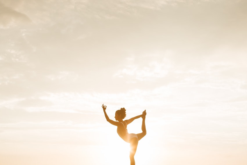 position de yoga effectuee par une jeune femme soleil couchant