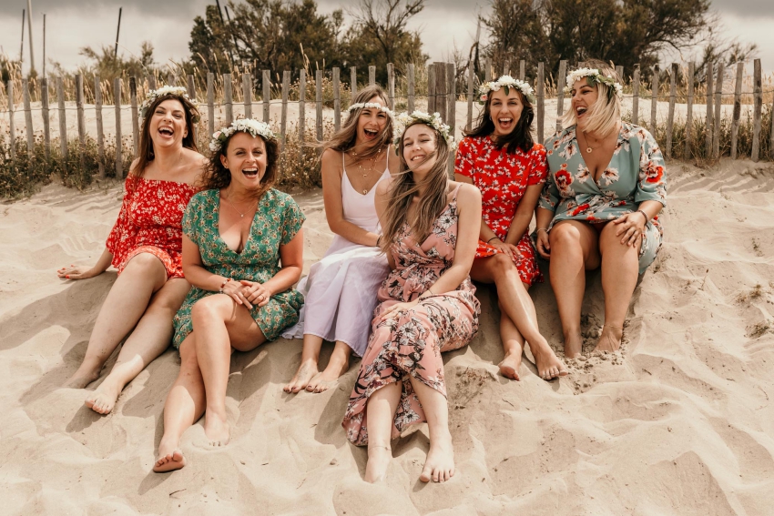groupe de filles sur la plage avec des couronnes de fleurs