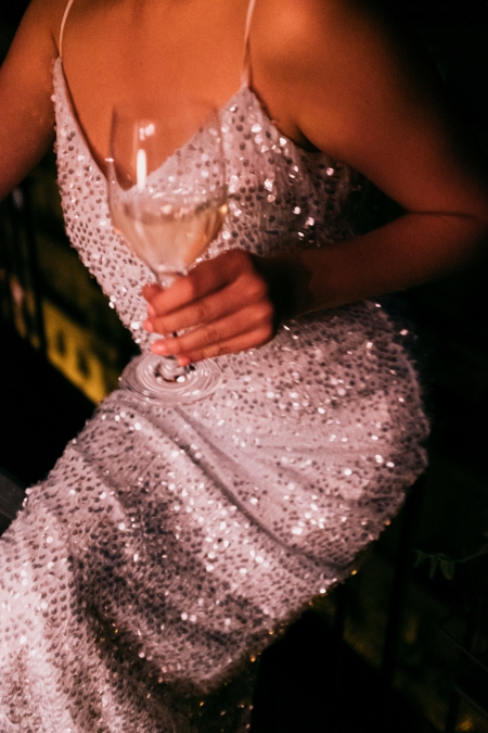 femme en robe a sequin argente avec coupe de champagne