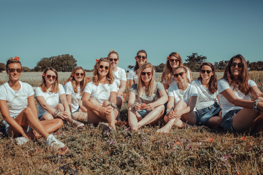 groupe de femmes assisent dans un champ de coquelicots