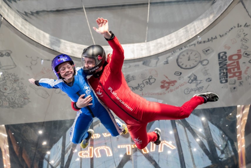 jeune femme qui effectue le simulateur de chute libre avec un accompagnateur