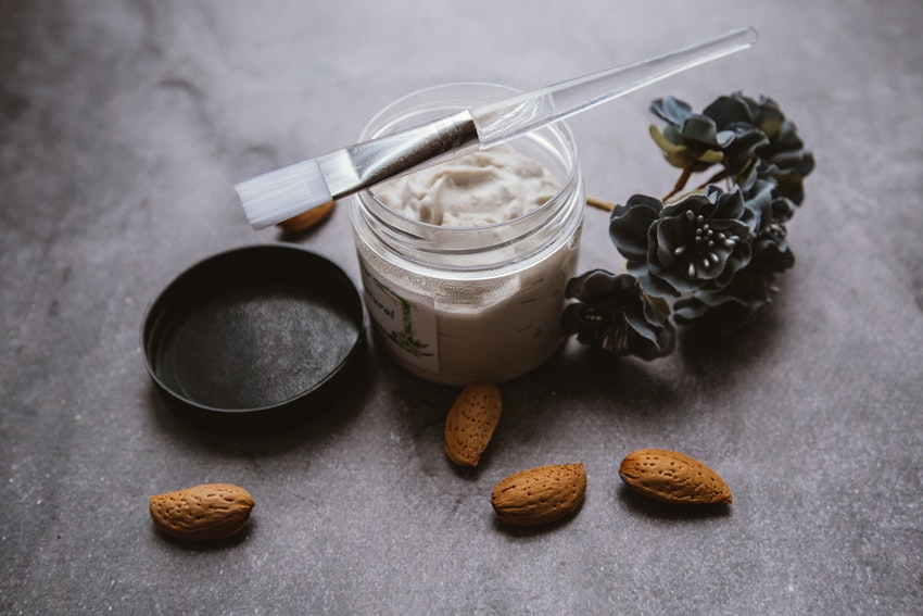 pot de creme avec fleurs et pinceau