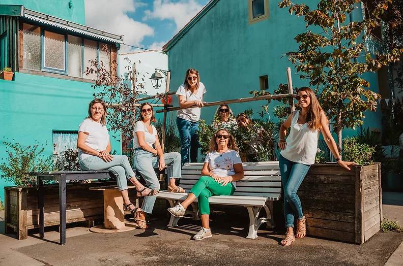 Un groupe de femmes posant lors d'un EVJF à Nantes, assises et debout dans un espace urbain coloré et verdoyant.