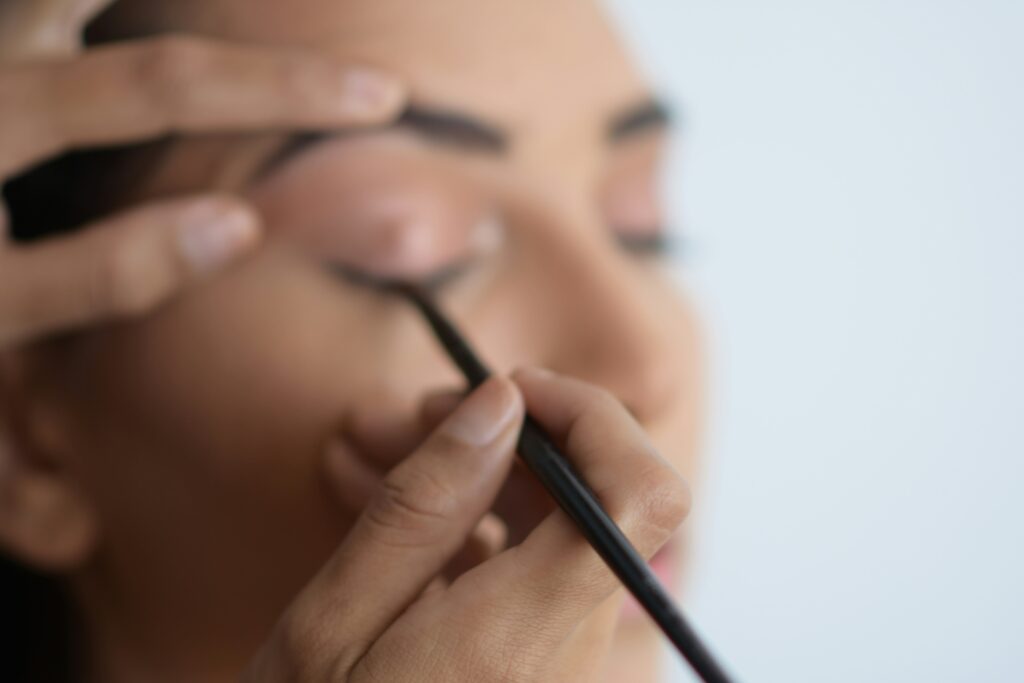 Maquilleuse professionnelle réalisant un maquillage sur une future mariée lors d’un EVJF à Annecy.