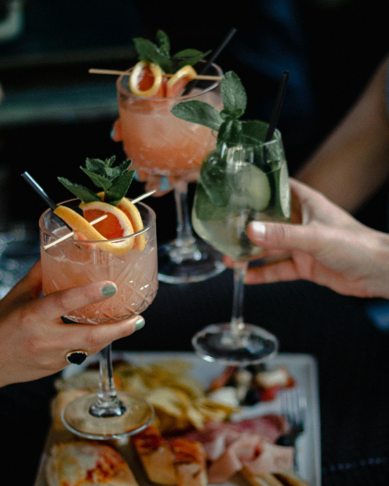 Verres de cocktails élégamment décorés tenus par des participantes lors d’un atelier de mixologie EVJF à Annecy.