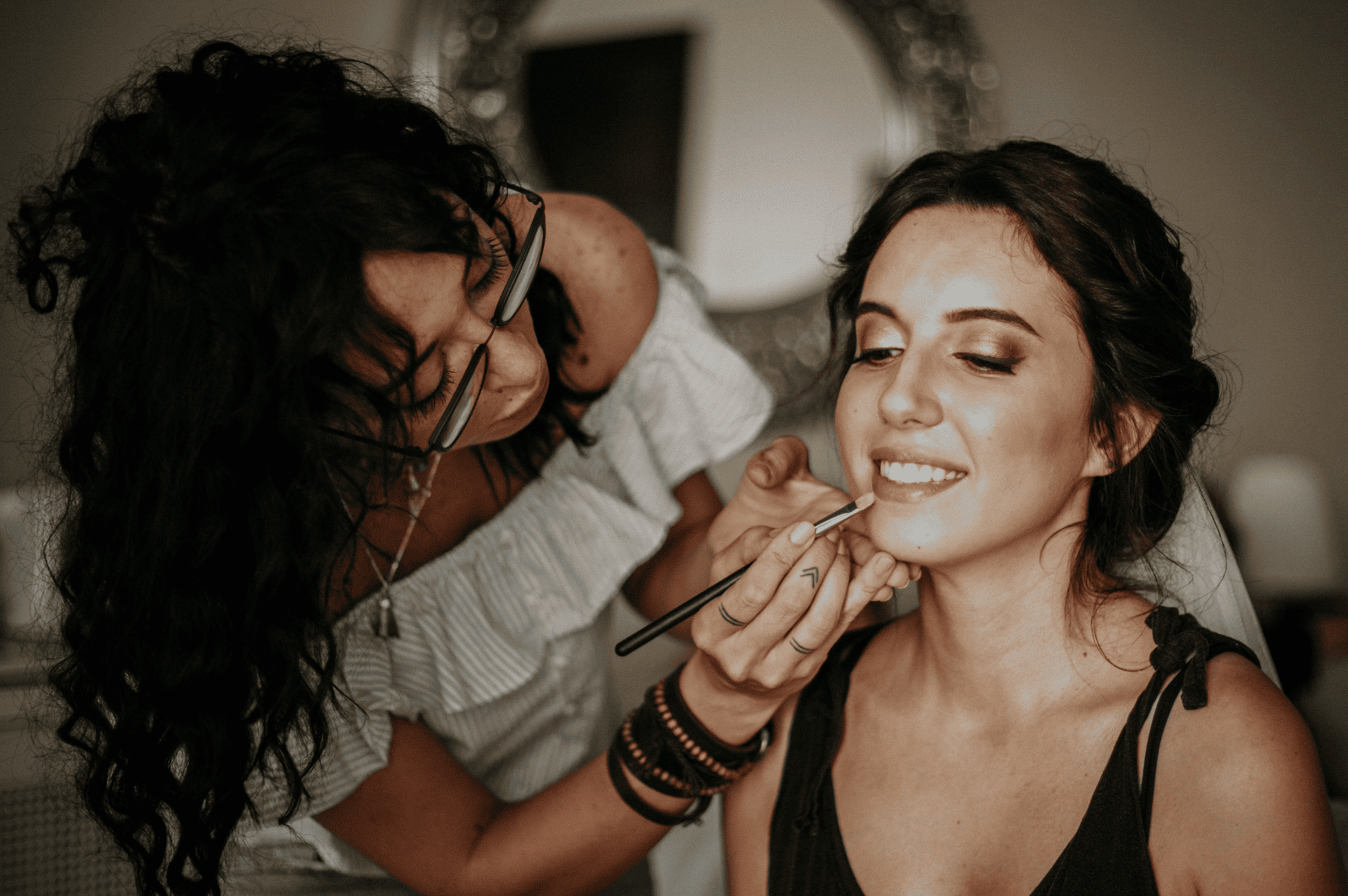 Atelier bien-être EVJF : la future mariée se fait maquiller par une professionnelle pendant que ses amies profitent de conseils beauté dans une ambiance conviviale.