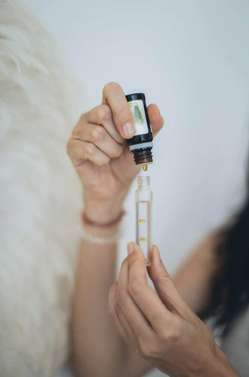 Atelier création de parfum EVJF à Toulouse, participante testant une fragrance dans un flacon en verre, ambiance élégante et sensorielle