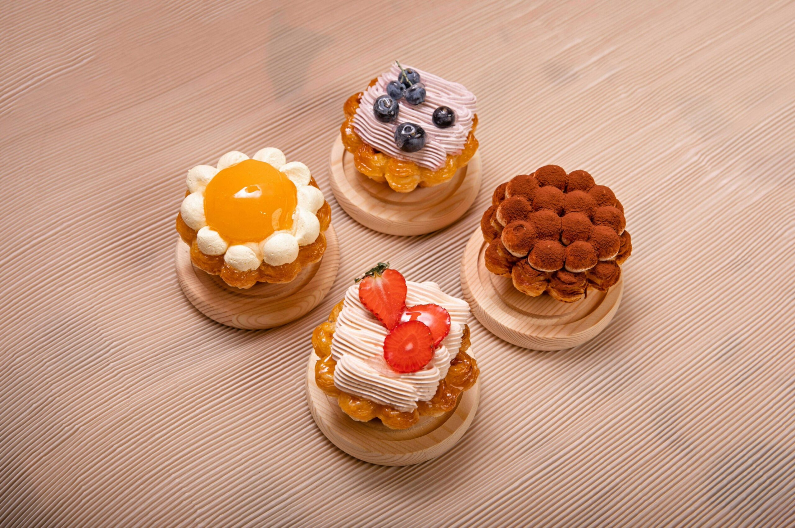 Plan de travail joliment préparé pour un atelier pâtisserie EVJF à Lille, avec des ustensiles, des poches à douille, des bols d’ingrédients sucrés, et une décoration avec les lettres "EVJF" en fleurs posées sur la table.