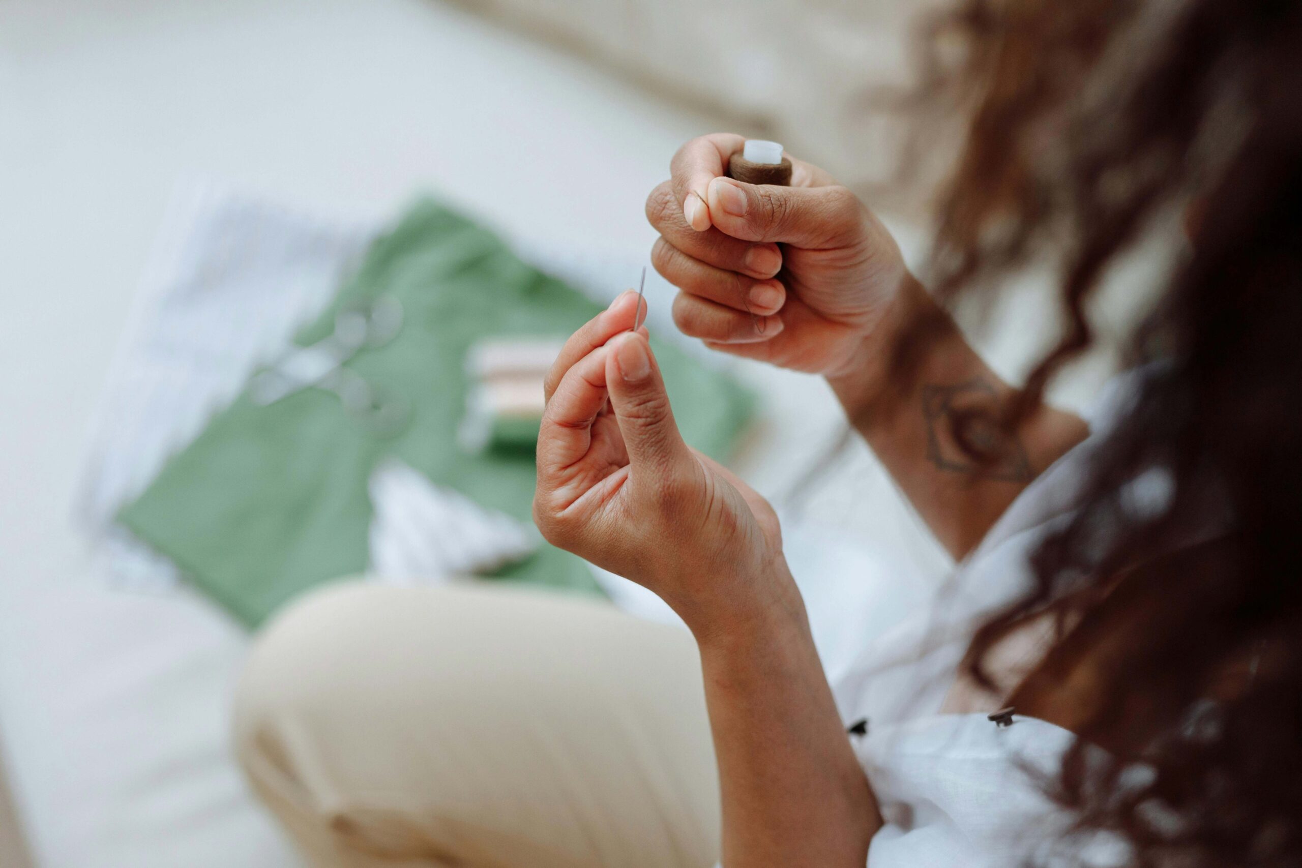 Groupe de femmes participant à un atelier broderie à Lille pour un enterrement de vie de jeune fille, concentrées et souriantes autour d’un espace créatif avec tambours à broder, fils colorés et ambiance cosy.