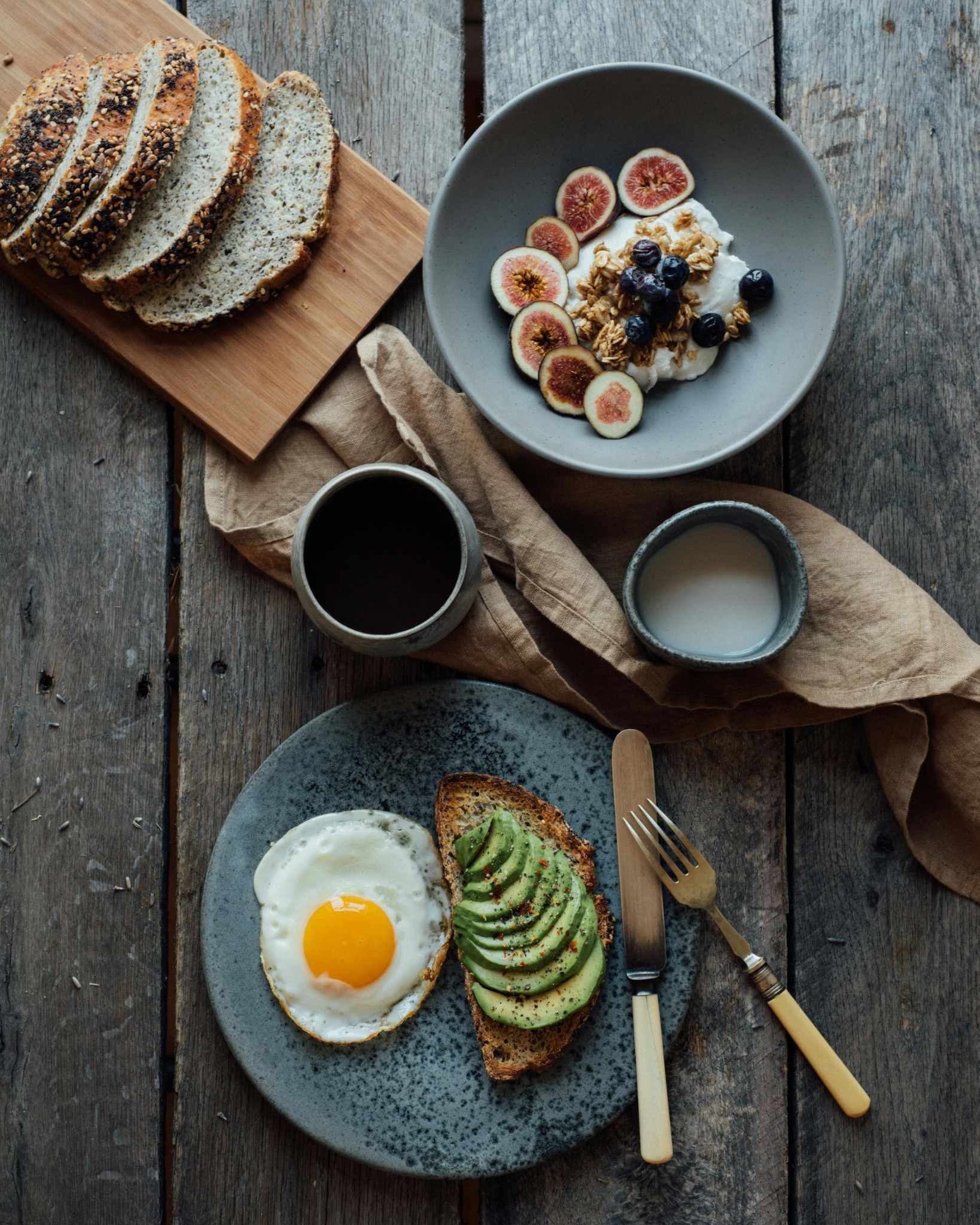 Petit-déjeuner raffiné avec tartine d’avocat et œuf au plat, bol de yaourt aux fruits frais et granola, idéal pour un Brunch EVJF à Marseille.