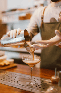 Atelier cocktail en cours pendant un EVJF à Lyon, avec des participantes en pleine préparation de leurs boissons.