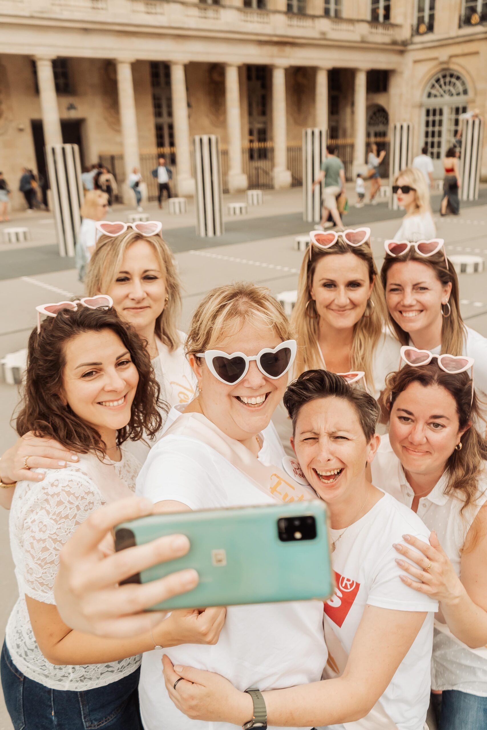 Groupe de femmes souriantes en tenue colorée en train de tourner un clip vidéo EVJF dans les rues de Lyon.