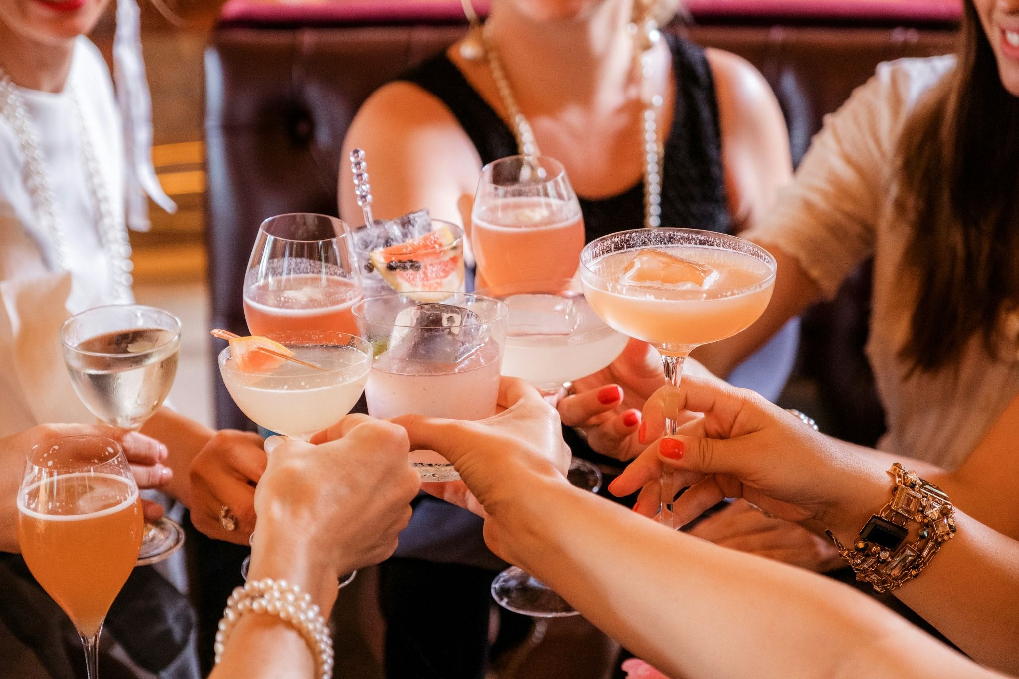 Groupe de femmes trinquant avec des cocktails colorés pendant un atelier EVJF à Annecy, dans une ambiance chic et conviviale.