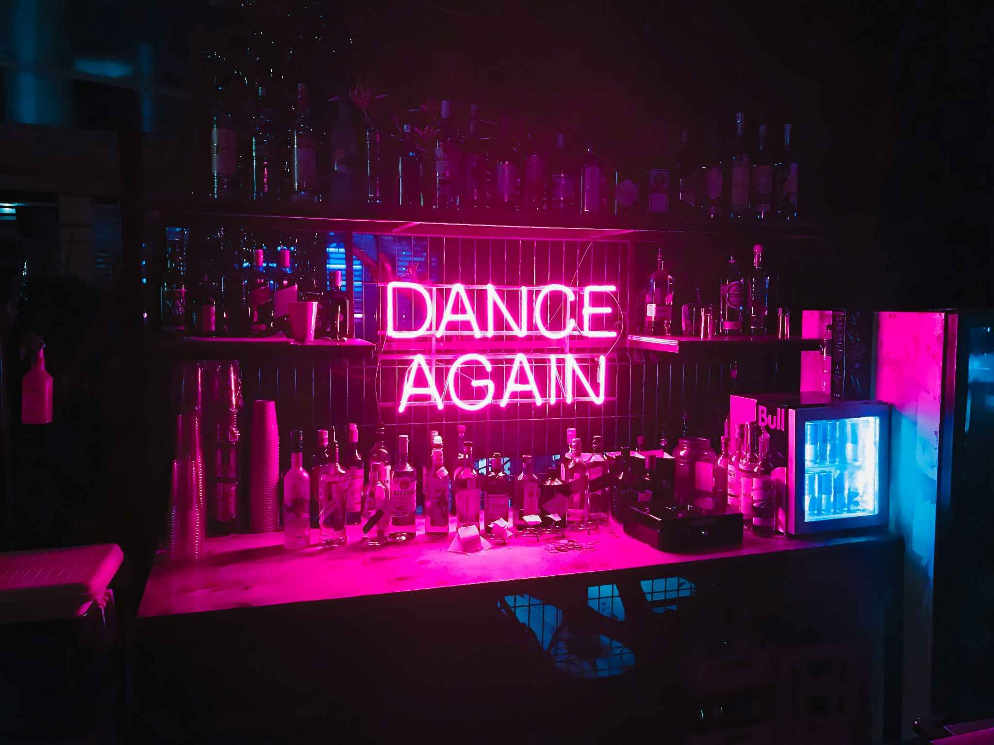 Bar lumineux avec enseigne néon "Dance Again", ambiance festive d’une soirée EVJF.