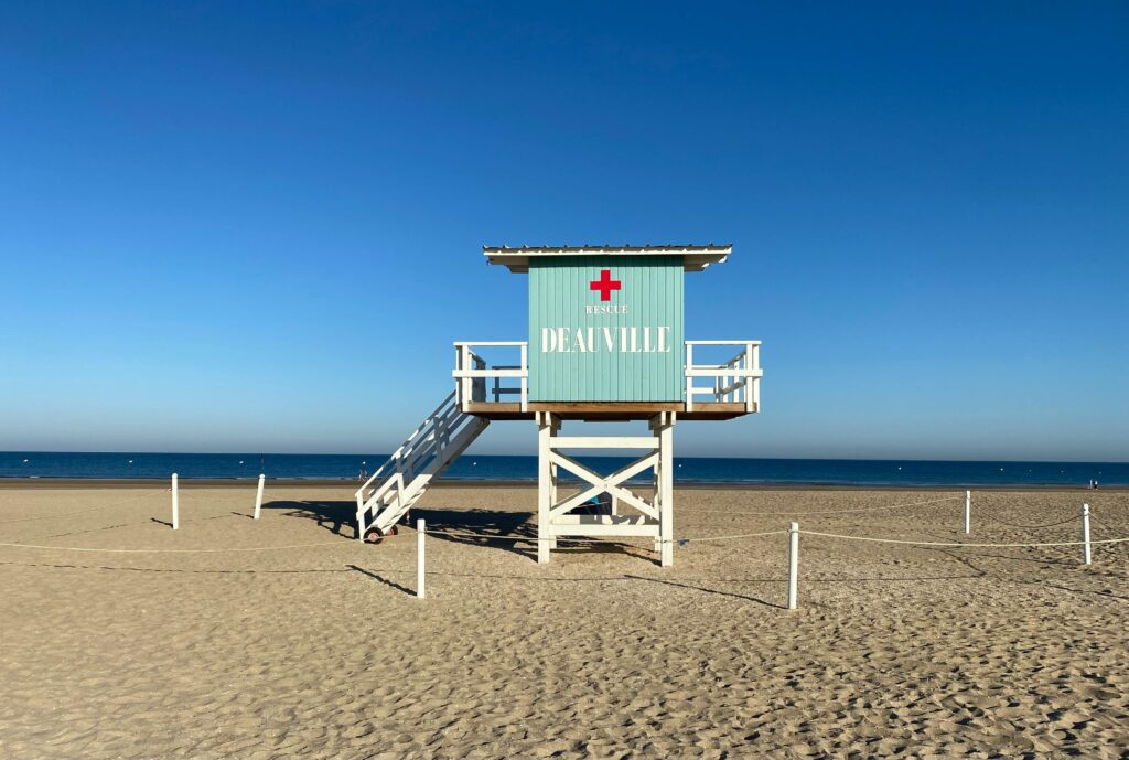Plage de Deauville en été avec parasols colorés et ciel bleu