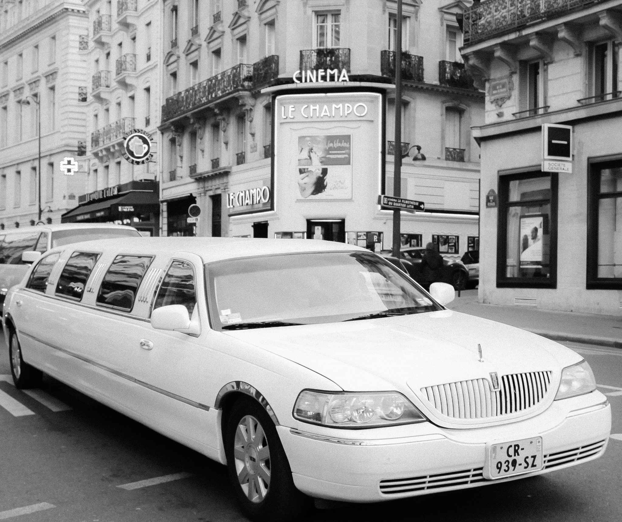 Limousine blanche garée devant un bâtiment élégant en centre-ville, prête pour une balade chic à Deauville