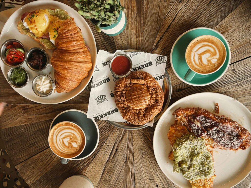 Table élégamment dressée avec viennoiseries, plats salés et cafés gourmands pour un brunch EVJF à Marseille.