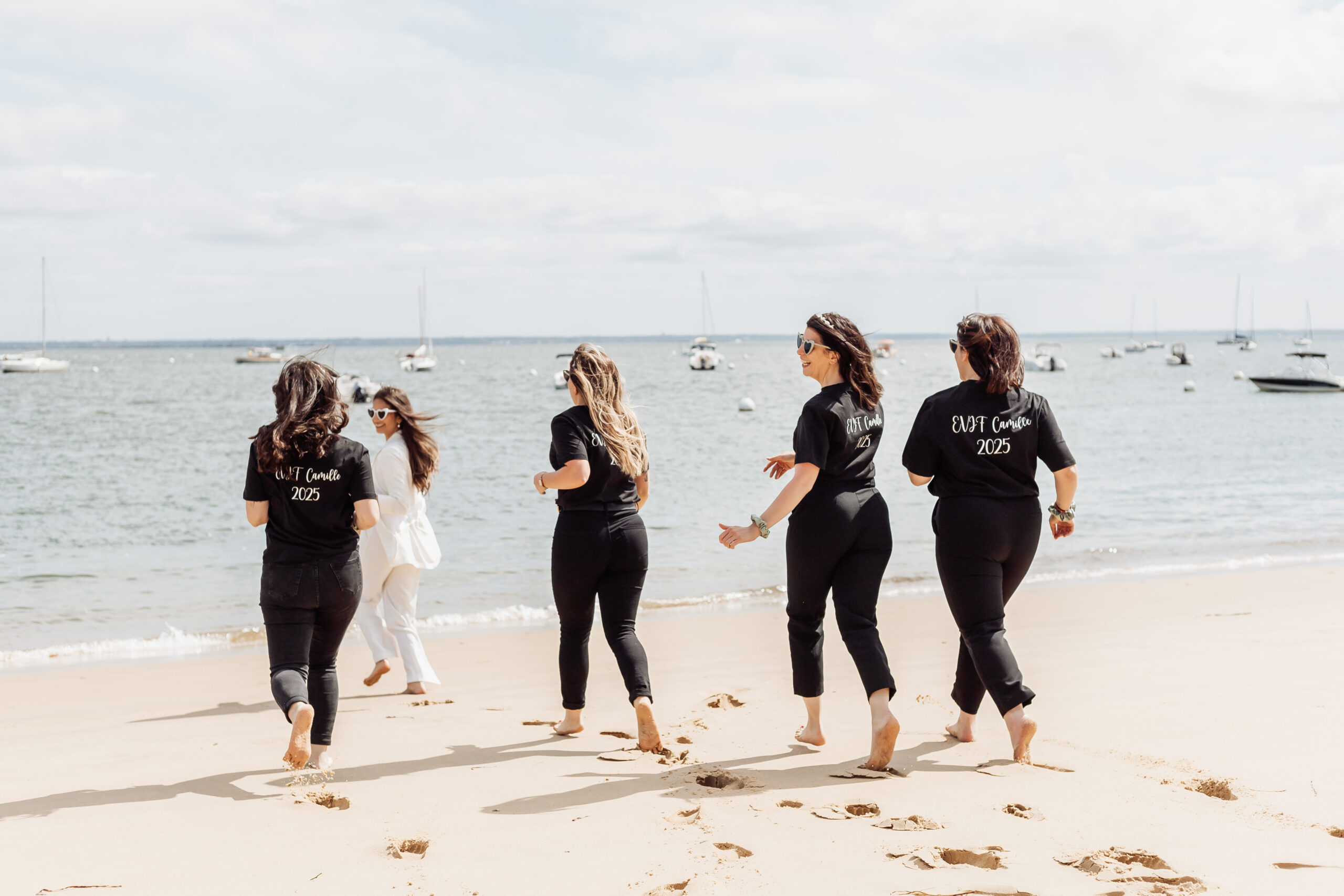 Groupe de femmes souriantes posant sur la plage lors d’un shooting photo EVJF à Arcachon