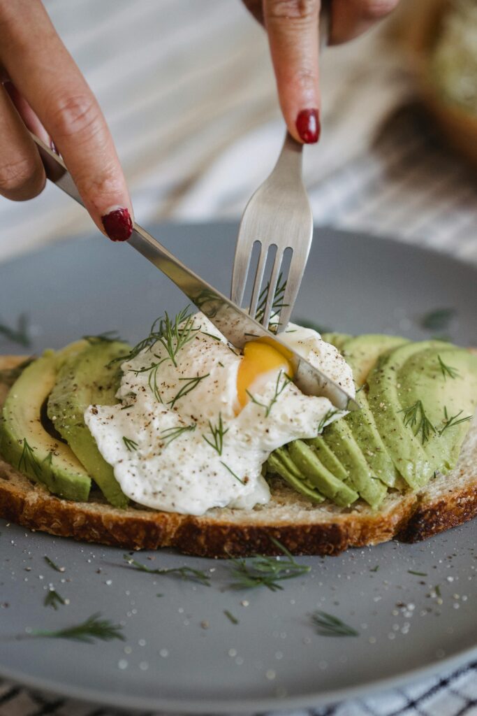 Gros plan sur une tartine d’avocat et œuf poché dégustée lors d’un brunch EVJF à Marseille