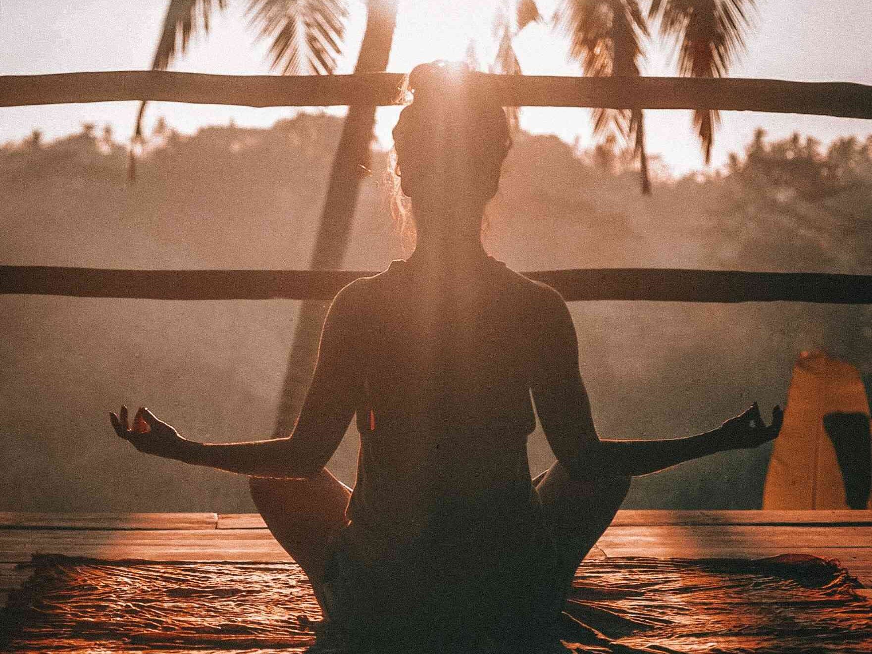 Groupe de femmes pratiquant le yoga sur la plage de Deauville pendant un EVJF au lever du soleil

