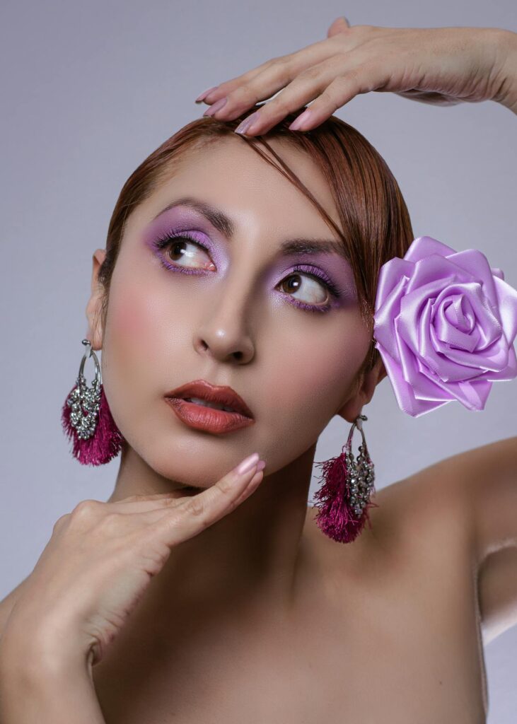 Femme maquillée avec des accessoires violets lors d’un atelier beauté EVJF à Biarritz