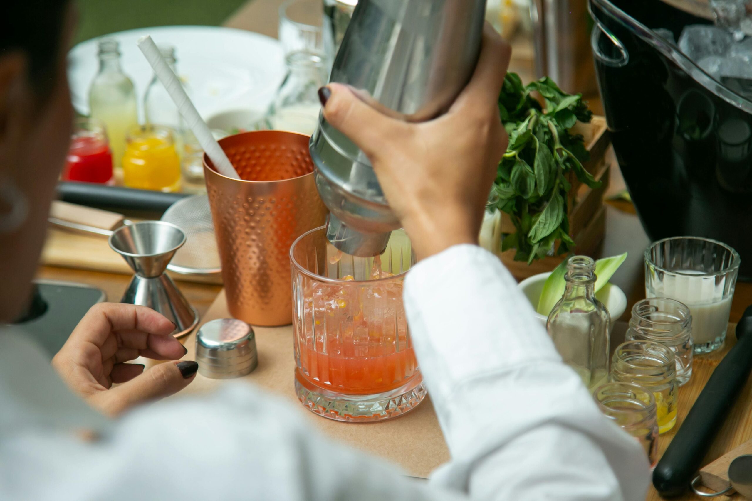 Mains en train de préparer un cocktail lors d’un atelier mixologie EVJF Lyon.