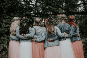 Groupe de femmes de dos portant leurs couronnes de fleurs créées lors d’un atelier EVJF à Toulouse, ambiance bohème et festive