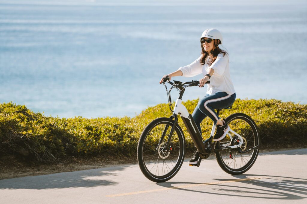 Femme en tenue décontractée pédalant en bord de mer lors d’une balade EVJF à vélo électrique à Biarritz