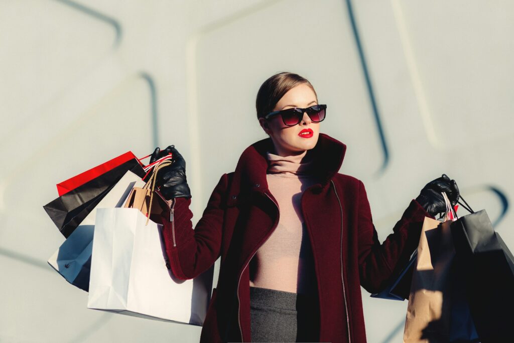 Femme chic avec sacs de shopping après une séance conseil en image à Biarritz