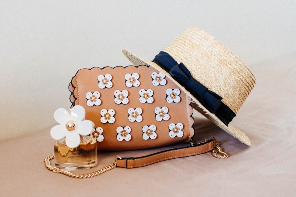 Sac à main fleuri, chapeau et parfum Daisy pour un atelier style EVJF à Biarritz