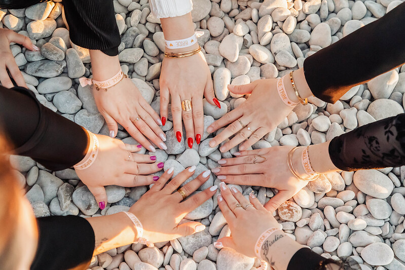 Mains de femmes formant un cercle pendant une chasse au trésor EVJF à Nice, symbole d’équipe et de complicité.