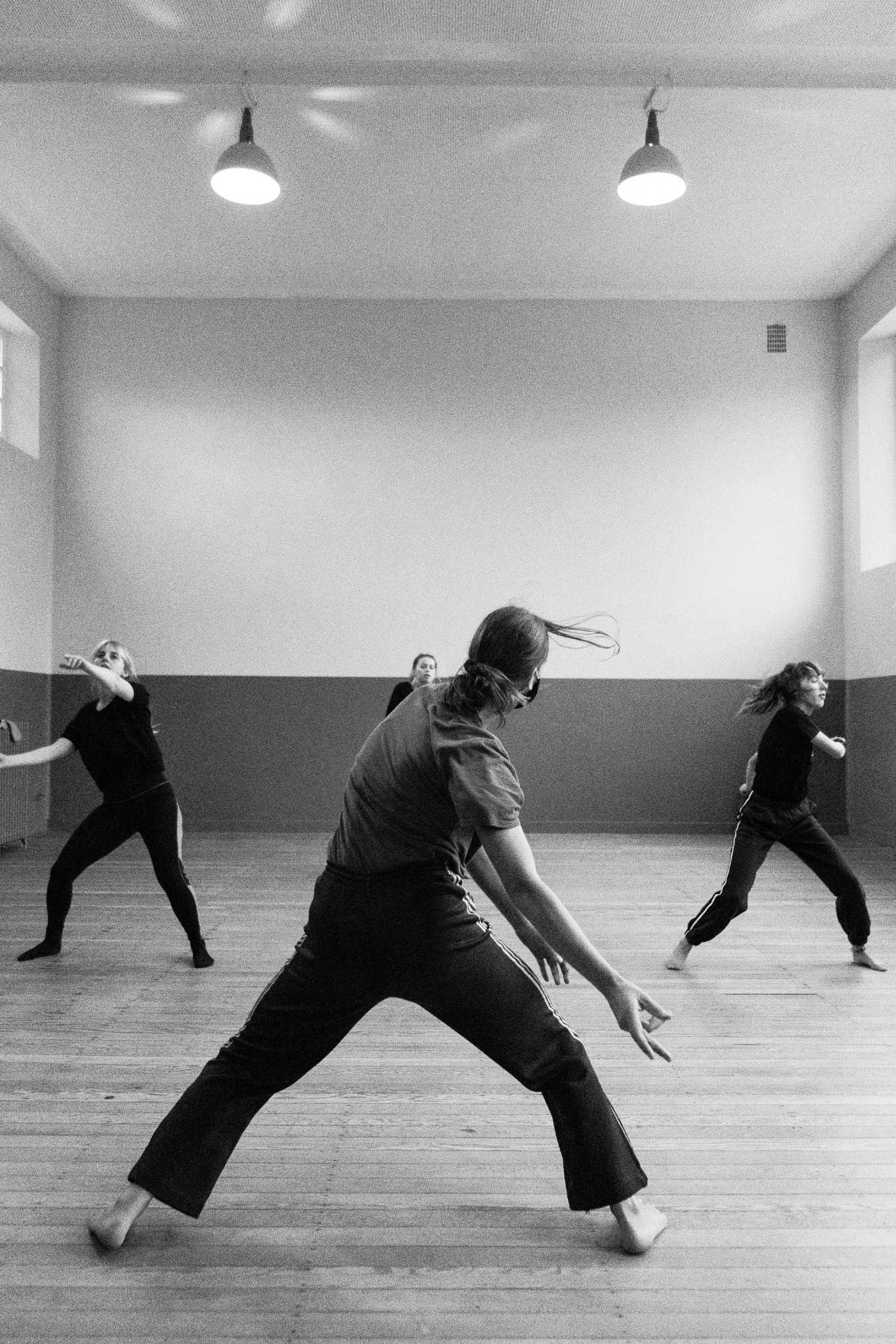 Groupe de femmes en plein mouvement pendant un cours de danse énergique, dans une salle minimaliste à Annecy pour un EVJF.