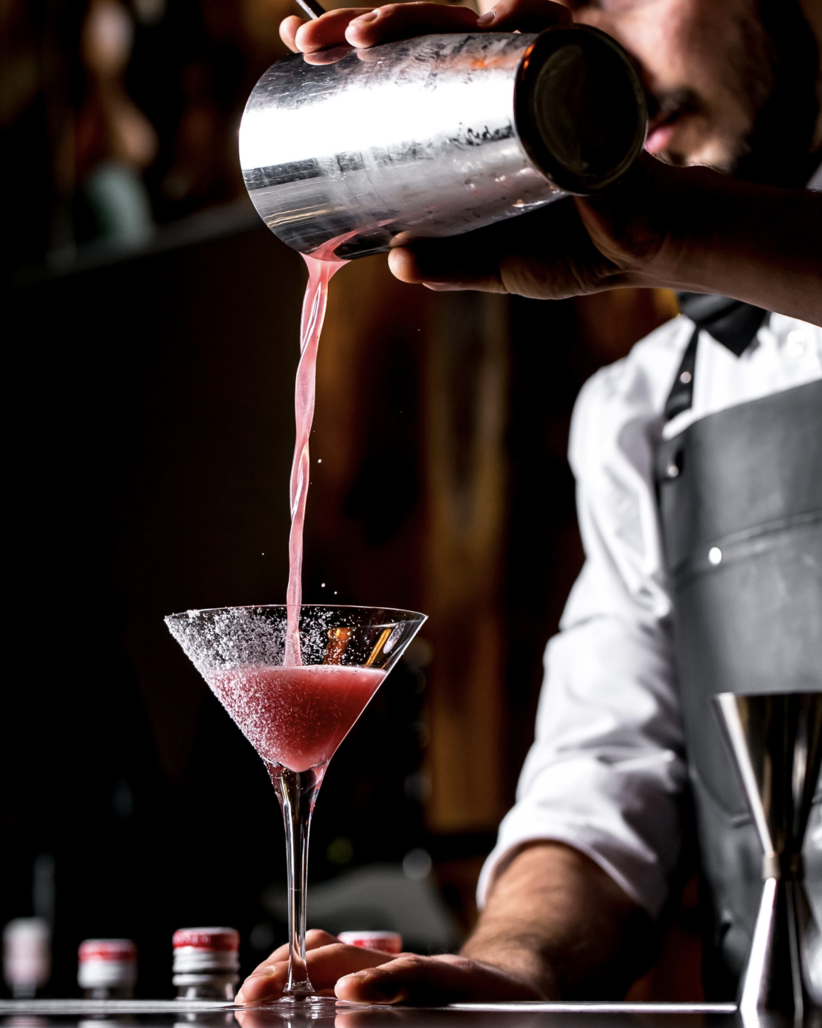 Atelier cocktail EVJF à Toulouse, participante secouant un shaker en pleine préparation de cocktail, ambiance dynamique et festive