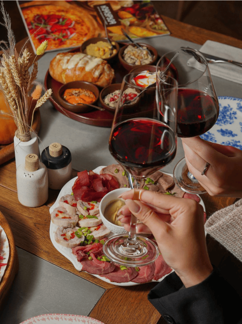 Groupe de jeunes femmes partageant un dîner festif dans un restaurant à Strasbourg, rires et ambiance chaleureuse autour d’une belle table.