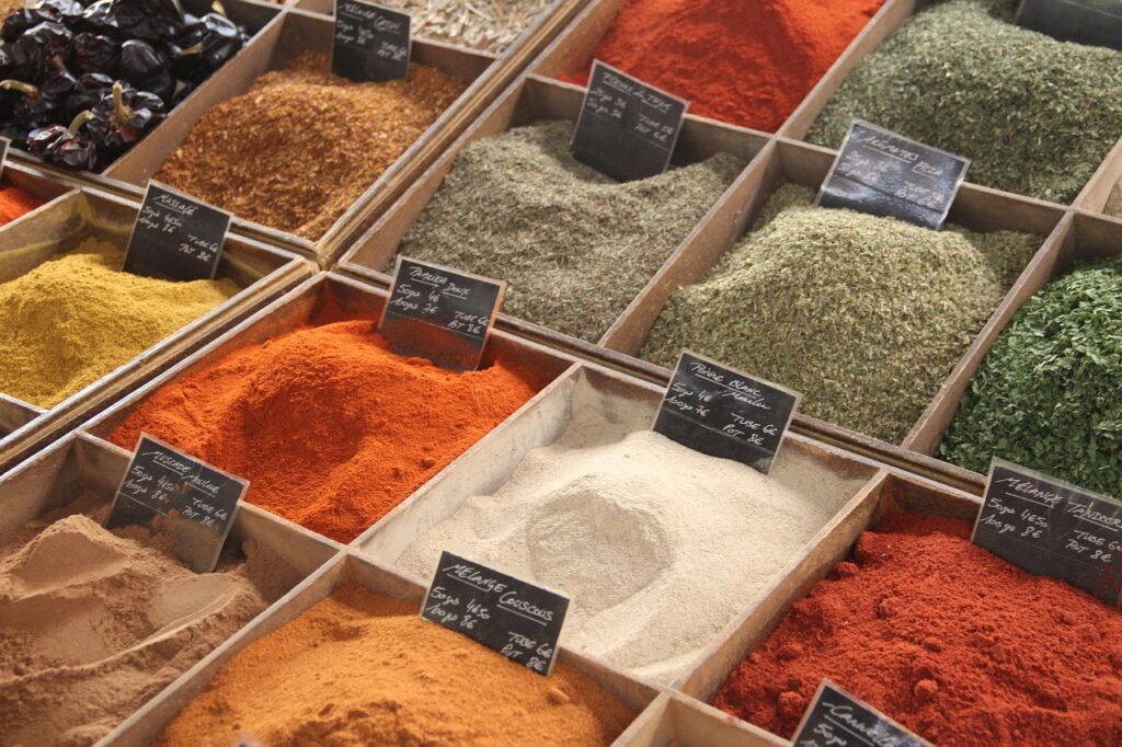 alt="Étal d’épices colorées au marché des Halles de Biarritz pendant une activité EVJF"