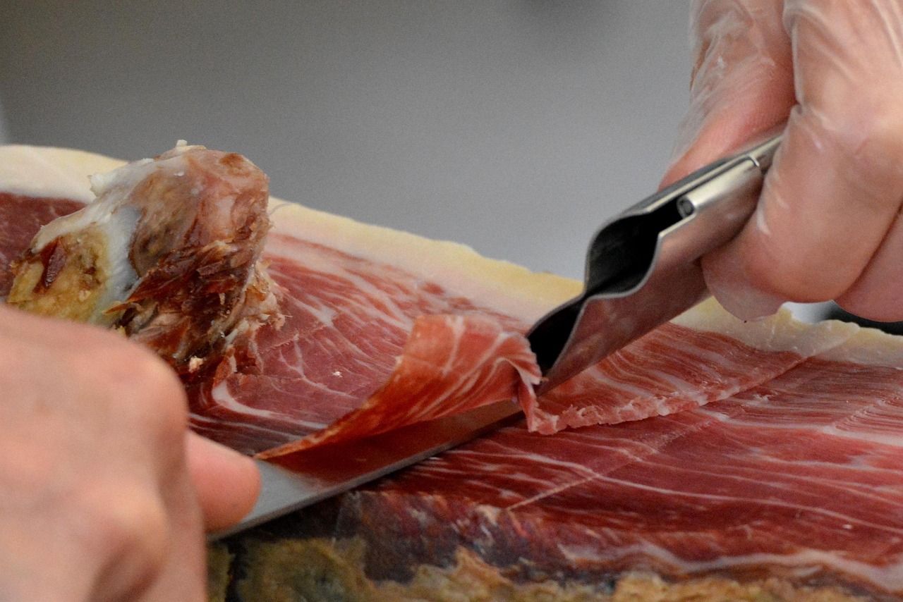 alt="Détail d’une découpe de jambon basque pendant une dégustation lors d’un EVJF à Biarritz"