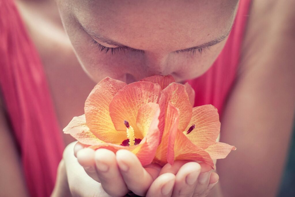 Jeune femme sentant une fleur lors d’un atelier de création de parfum EVJF