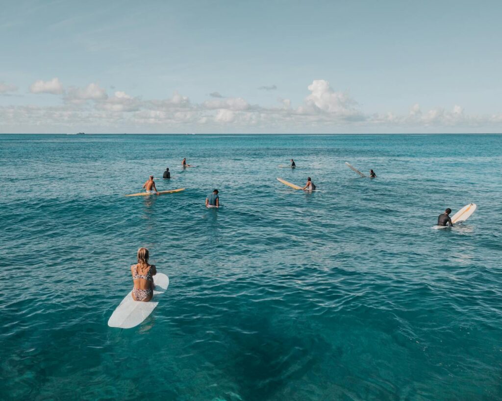 Groupe de filles assises sur leurs planches de surf pendant une initiation à Biarritz